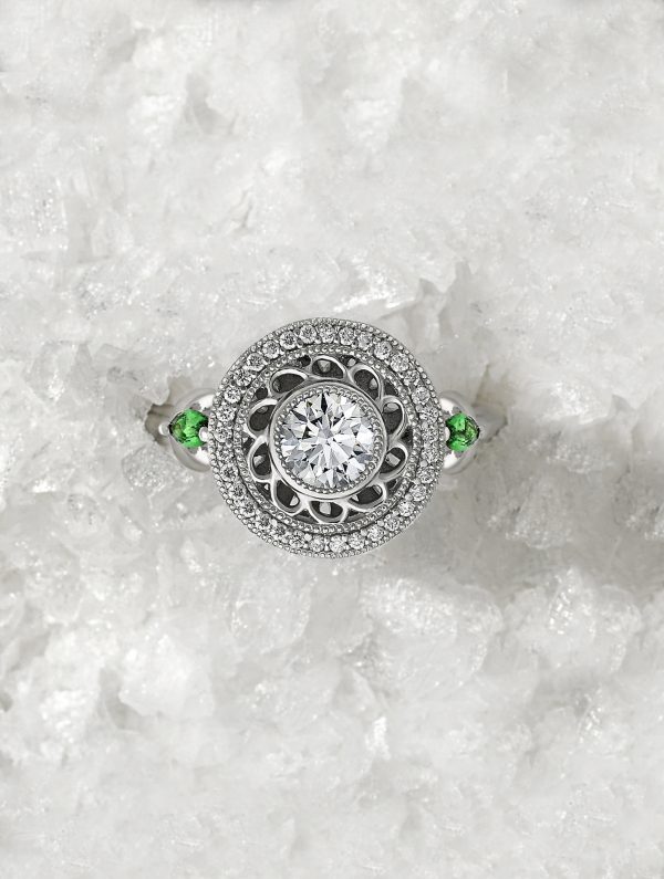 round diamond with filigree detail halo with Marquise tsavorites set in platinum