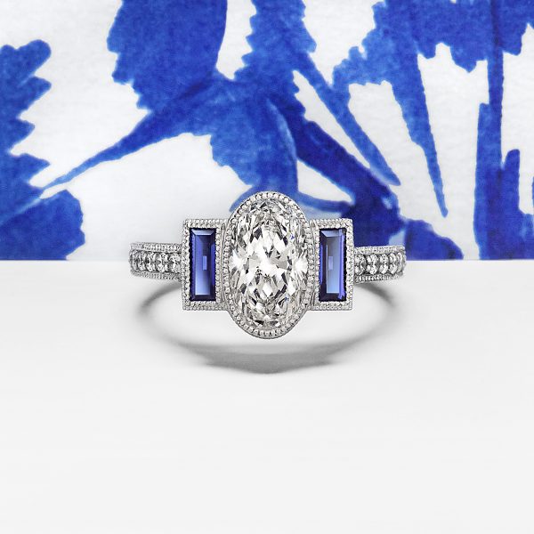 oval diamond with blue sapphire baguettes hand engraving and milgrain