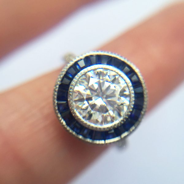 round diamond with blue sapphire custom cut halo and milgrain detail