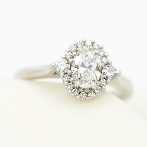 oval diamond with accent round diamond halo engagement ring